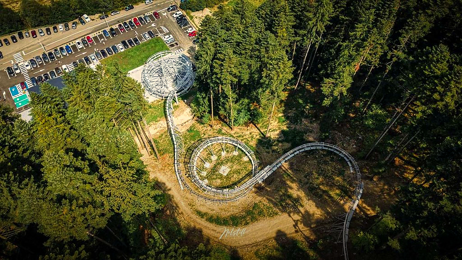 Die Strecke des Forest Coaster aus der Luft: die Schleife, der Parkplatz und der Wald ringsum