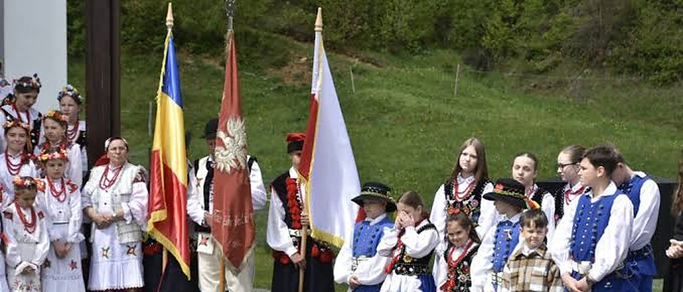 Die rumänische und die polnische Fahne nebeneinander, vor Kindern in Goralentracht